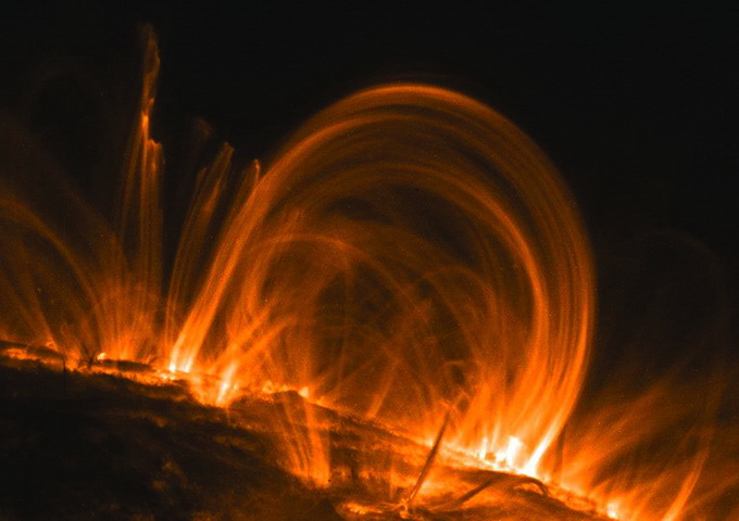 從光球層和色球層竄出到達日冕層的熱離子氣體群，好像貼附在太陽邊緣的耳環，稱為日珥。（圖片來源：http://solarsystem.jpl.nasa.gov/multimedia/gallery/coronaloop_trace_big.jpg）