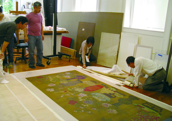 西尾（Yoshi Nishio，戴眼鏡站立者）主持的古畫修復工作室。