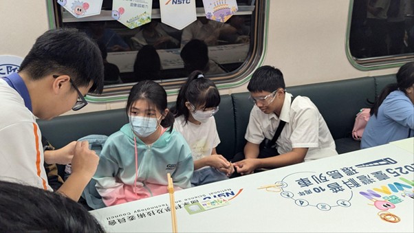 圖 2 坐在小朋友之間的助教，讓製作竹筷橡皮筋槍的過程更順利。圖片來源：王嘉萍老師提供